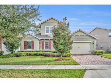 Two-story house with stone accents and a landscaped lawn at 14157 Creekbed Cir, Winter Garden, FL 34787