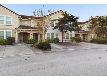 Charming townhome with a red tile roof, arched entryway and well-maintained landscaping at 4775 Terrasonesta Dr, Davenport, FL 33837