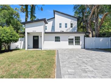 Stunning two-story modern home showcasing a minimalist design with black and white colors and a well-manicured lawn at 5255 Seminole Ave, Winter Park, FL 32792