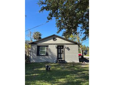 Charming one-story home with a brick exterior and a well-maintained front yard under a blue sky at 1320 S Oleander Ave, Sanford, FL 32771
