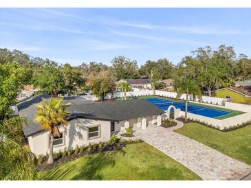 Stunning home features a tennis court, a patterned brick driveway, and a lush landscaped yard at 2337 Worthington Rd, Maitland, FL 32751