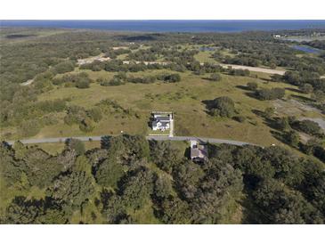 An aerial view of the property showing the house, land, nearby trees, and the neighborhood at 3705 Ridge Run Dr, Minneola, FL 34715