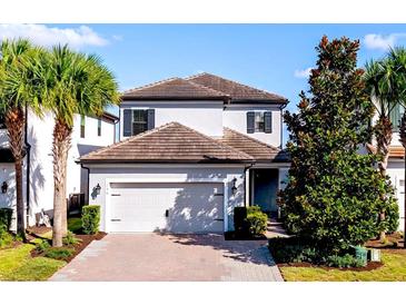 Charming two-story home featuring a well-manicured front yard, brick driveway and attached two car garage at 1219 Verdant Glade Pl, Winter Park, FL 32792