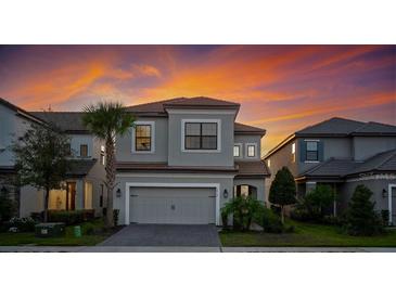 Two-story home showing modern architectural details, a two-car garage and a beautifully landscaped front yard at sunset at 1312 Blue Stem Ln, Winter Park, FL 32792