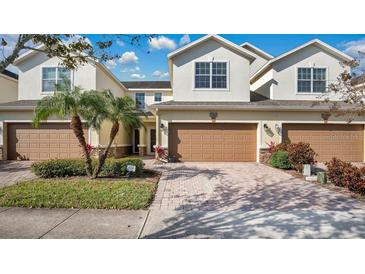 Two-story townhome with attached garage and landscaped front yard at 564 Woodland Terrace Blvd, Orlando, FL 32828