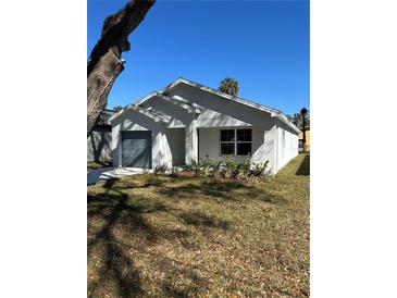 Newly constructed single-story home featuring neutral color palette and attached one-car garage on a sunny day at 1621 Pear Ave, Sanford, FL 32771