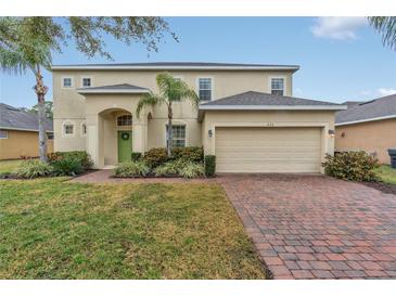 Two-story house with a two-car garage and landscaped front yard at 256 Yellow Snapdragon Dr, Davenport, FL 33837
