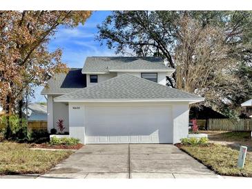 Charming home featuring an attached two-car garage, green lawn, and beautiful landscaping at 10632 Whitestone Ct, Orlando, FL 32817