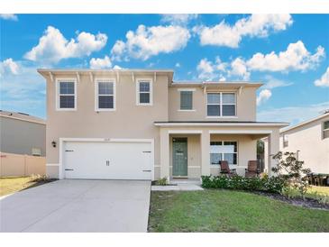 Two-story house with a green door and a white garage door at 11237 Amber Ridge Dr, Zellwood, FL 32798