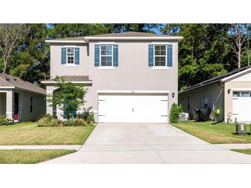 Two-story house with gray siding, white garage door, and blue shutters at 368 Pelham Park Dr, Deland, FL 32720