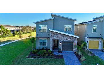 Modern two-story home with gray siding and stone accents at 8900 Takeaway Way, Davenport, FL 33896