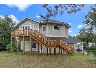 Elevated home with wrap-around deck, detached garage, and RV parking at 1399 Old Mount Dora Rd, Eustis, FL 32726