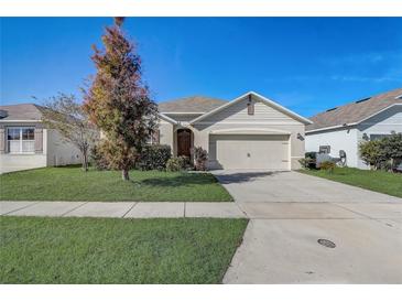 One-story house with a two-car garage and well-manicured lawn at 273 St Georges Cir, Eagle Lake, FL 33839