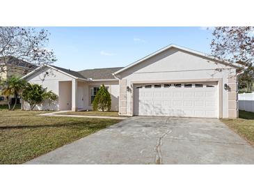 Single-story house with a two-car garage and well-maintained lawn at 548 Hummingbird Ct, Poinciana, FL 34759