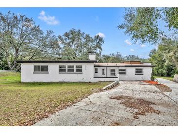 White single story home with a large yard and driveway at 6424 Sleepy Hollow Dr, Orlando, FL 32810