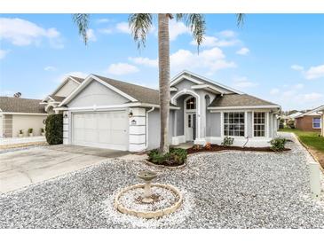 Single-story house with gray siding, two-car garage, and landscaped front yard at 843 Challenger Ave, Davenport, FL 33897