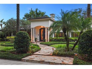 Elegant home with stone pathway, lush landscaping, and a captivating entryway at 1426 Nottingham St, Orlando, FL 32803