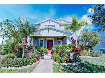 Two-story house with landscaped yard and a red front door at 14493 Windsor Hall Way, Winter Garden, FL 34787