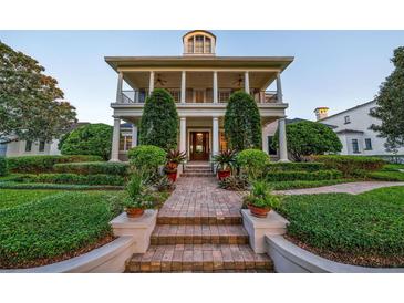 Two-story house with a classic facade, lush landscaping, and a brick pathway at 4424 New Broad St, Orlando, FL 32814