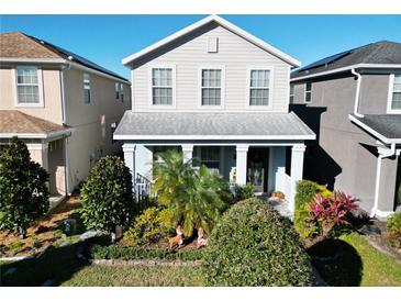 Two-story house with light beige siding, landscaping, and a front porch at 11743 Stein St, Orlando, FL 32832