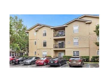 Tan three-story building with parking lot and several cars at 1341 Arbor Vista Loop # 113, Lake Mary, FL 32746