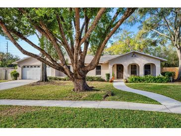 Single-story house with a large tree and landscaped yard at 5700 Marlberry Dr, Orlando, FL 32819