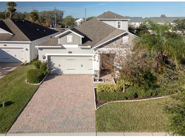 Two-story home with a paver driveway and landscaped yard at 1722 Farmstead Ln, Oviedo, FL 32765