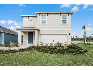 Two-story house with a white garage door and landscaping at 3432 Costello Cir, Winter Haven, FL 33884