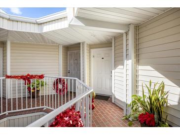 Inviting condo entryway with decorative wreaths and brick-paved flooring at 3900 Southpointe Dr # 127, Orlando, FL 32822