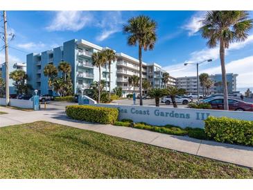 Sea Coast Gardens II building exterior, featuring palm trees and ample parking at 4153 S Atlantic Ave # 3070, New Smyrna Beach, FL 32169