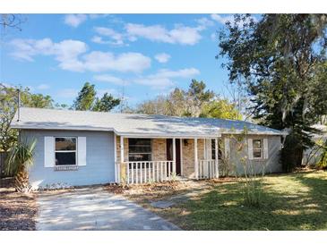 Light blue house with a covered porch and manicured lawn at 540 Fern Ave, Tavares, FL 32778