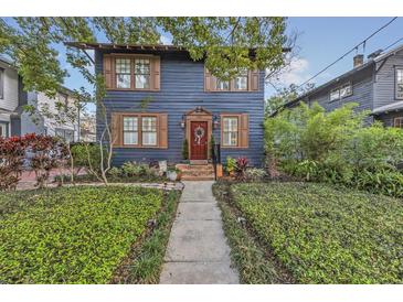 Charming two-story home with a well-manicured lawn, wood shutters, and a welcoming red front door at 606 E Amelia St, Orlando, FL 32803
