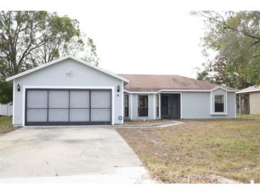 Gray house with attached garage and a spacious front yard at 741 Caribou Dr, Kissimmee, FL 34759