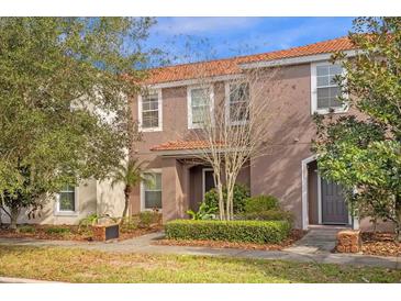 Two-story townhome with a charming front entrance and well-manicured landscaping at 1041 Las Fuentes Dr, Kissimmee, FL 34746