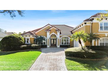 Luxury home with tile roof and landscaped yard, in upscale neighborhood at 1519 Lake Rhea Dr, Windermere, FL 34786
