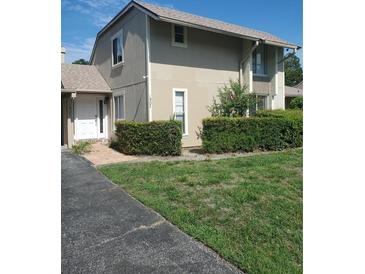 Tan two-story house with white door and well-manicured lawn at 1902 Abbington St # 1902, Apopka, FL 32712