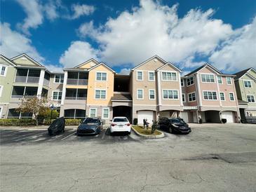 Multi-story condominium complex featuring attached garages, balconies, and convenient parking spaces at 6413 Astor Village Ave # 314, Orlando, FL 32835
