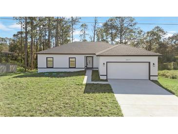 White house with gray roof, two-car garage, and a well-manicured lawn at 1608 Airmont Ave, Deltona, FL 32725