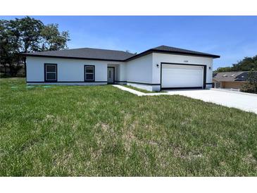 Charming single Gathering home with a crisp white exterior, black accents, and an attached two-car garage at 1608 Airmont Ave, Deltona, FL 32725