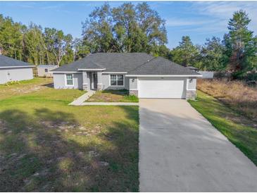 Newly built home with gray exterior, white garage door, and landscaped yard at 1780 Sw 168Th Loop, Ocala, FL 34473