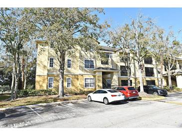 Exterior view of a two-story condo building with ample parking at 2572 Robert Trent Jones Dr # 1231, Orlando, FL 32835