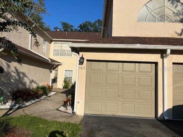 Townhouse exterior with attached garage and landscaped walkway at 3017 Cottage Grove Ct # Ge, Orlando, FL 32822