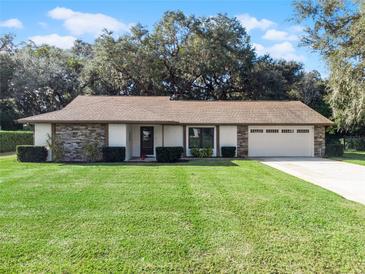 One-story home with stone accents, two-car garage, and lush lawn at 3158 Whisper Wind Dr, Saint Cloud, FL 34771