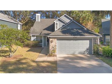 Gray two-story house with a gray garage door and a well-maintained lawn at 2799 Susanday Dr, Orlando, FL 32812