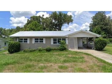 Ranch-style home with carport and mature landscaping at 127 W Palmetto Ave, Deland, FL 32720