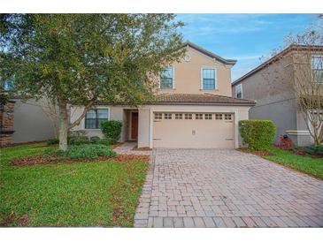 Two-story house with a two-car garage and a brick paved driveway at 1427 Wexford Way, Davenport, FL 33896