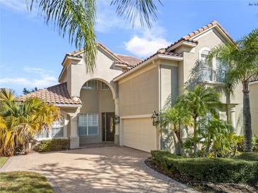 Stunning two-story home featuring lush landscaping, a brick driveway, tile roof, and a two-car garage at 1712 Whitney Isles Dr, Windermere, FL 34786