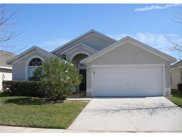 One-story house with attached garage, landscaping, and a light gray exterior at 603 Keppel Ct, Kissimmee, FL 34746