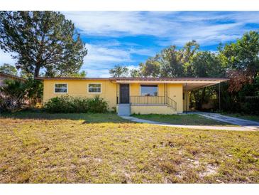 Ranch-style home with a yellow brick facade, and a spacious yard at 6150 Medford Dr, Orlando, FL 32808