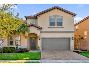 Two-story house with gray garage door and landscaping at 8824 Bengal Ct, Kissimmee, FL 34747